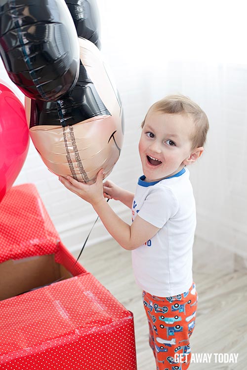 We're going to Disneyland boy hugging Mickey Balloon